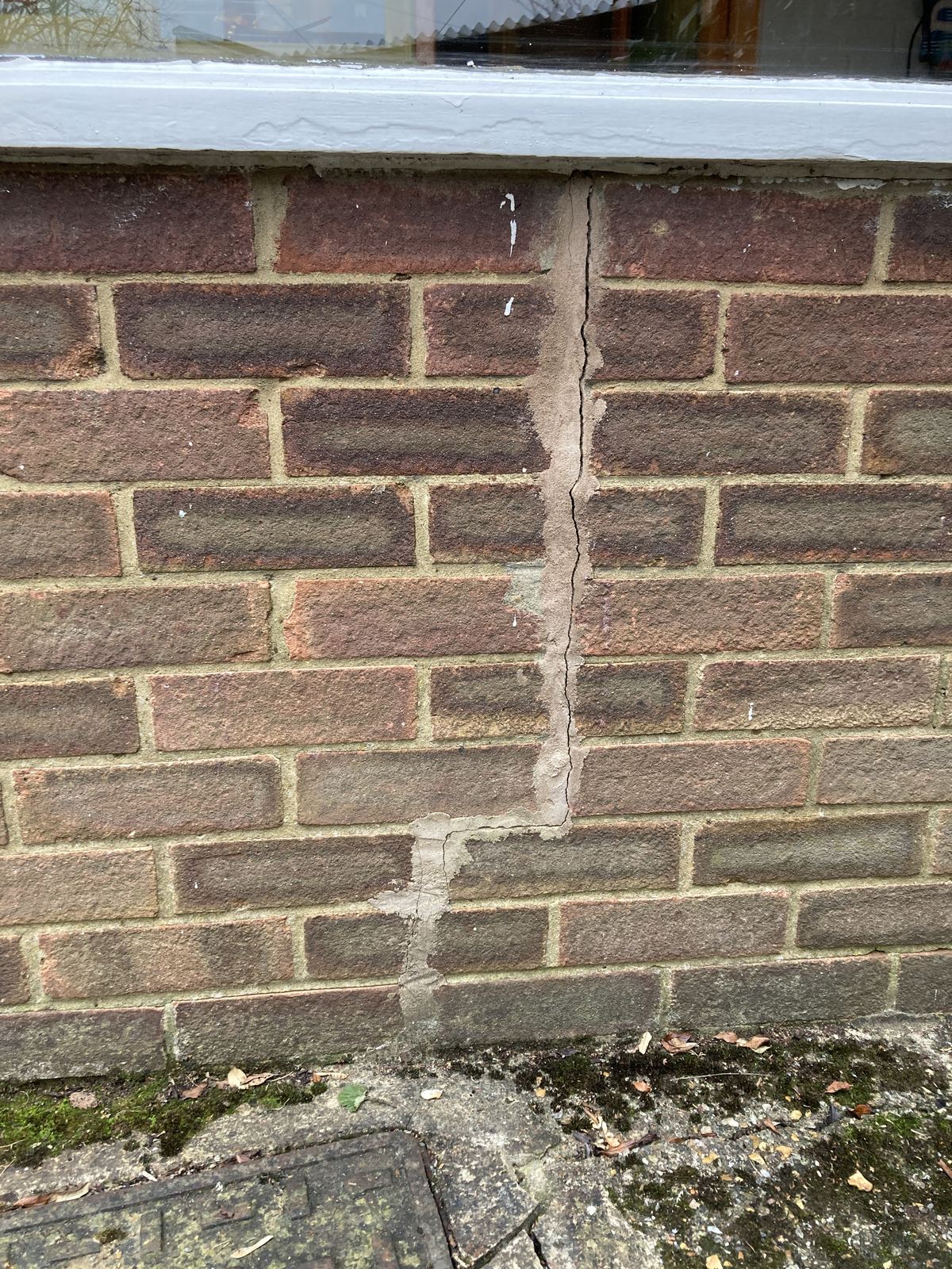 Vertical crack running through a brick parapet wall, photo 1 of 2