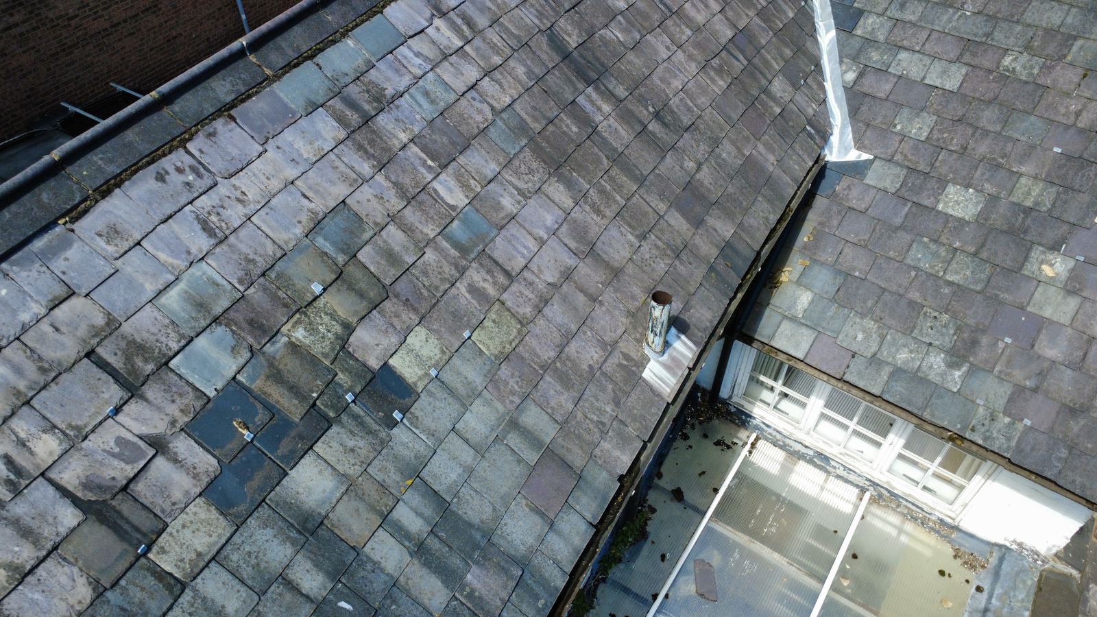 Slate roof slope beside a glazed roof light, photo 1 of 3