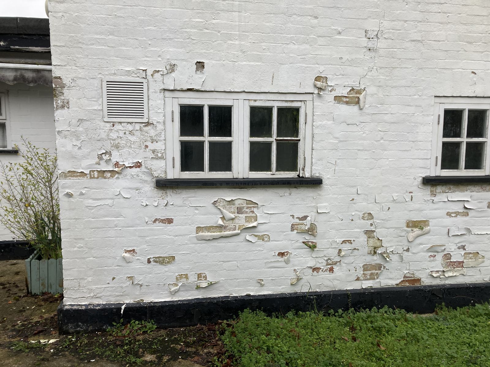 Painted brick wall with spalled and flaking paint, photo 2 of 6