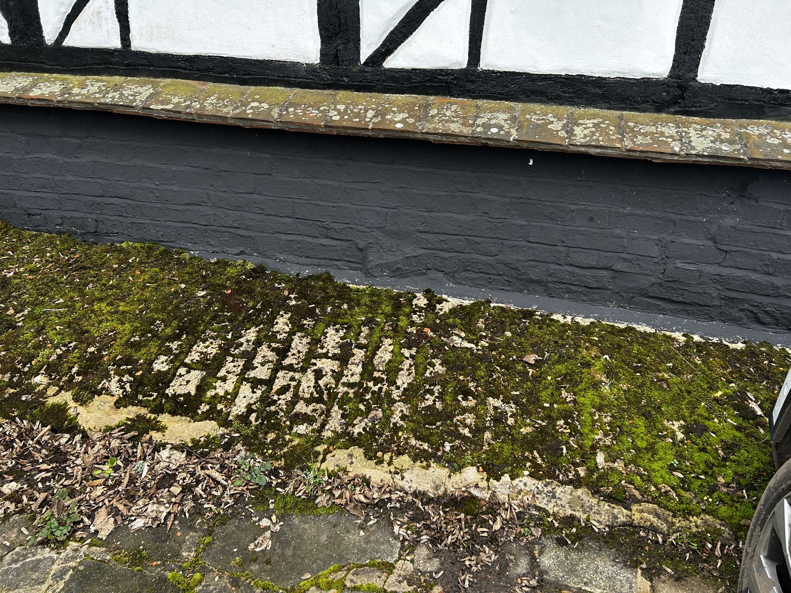 Moss-covered roof slope below a timber-framed wall, photo 1 of 2