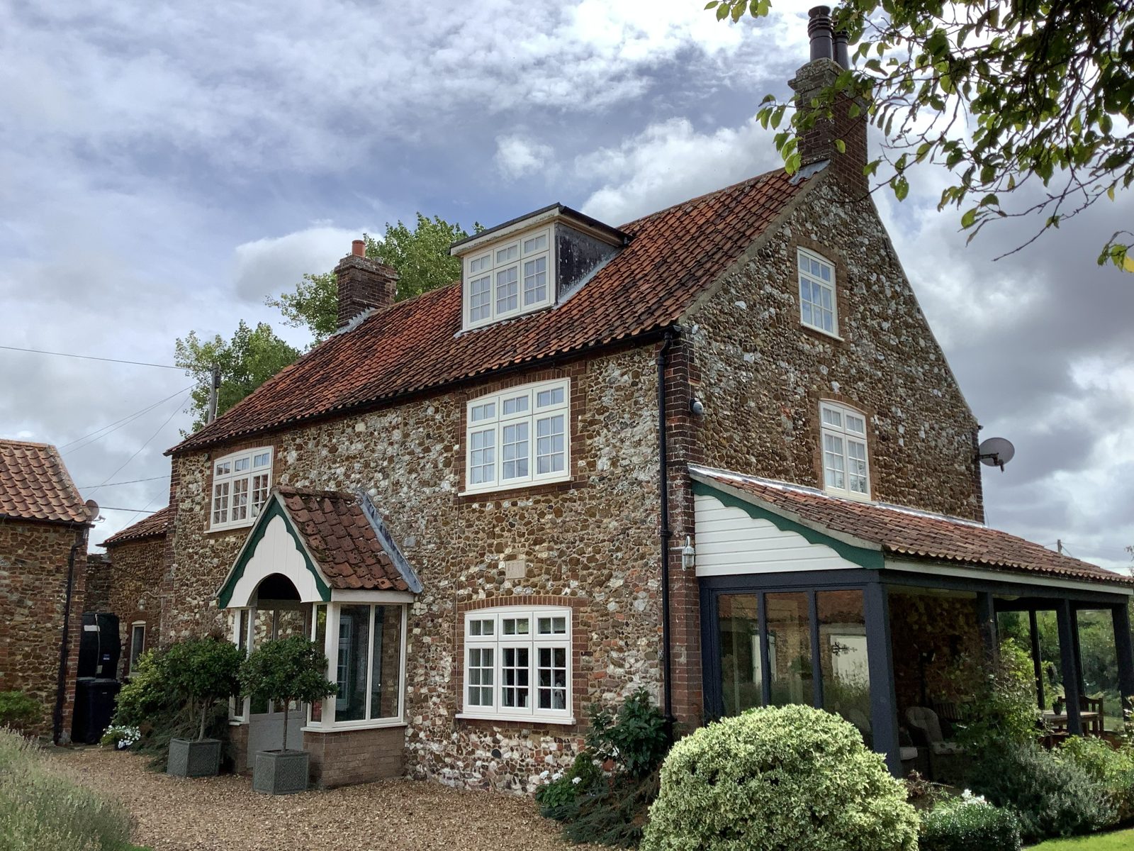 Flint and red brick farmhouse with a clay pantile roof, dormer and tiled porch, photo 3 of 4