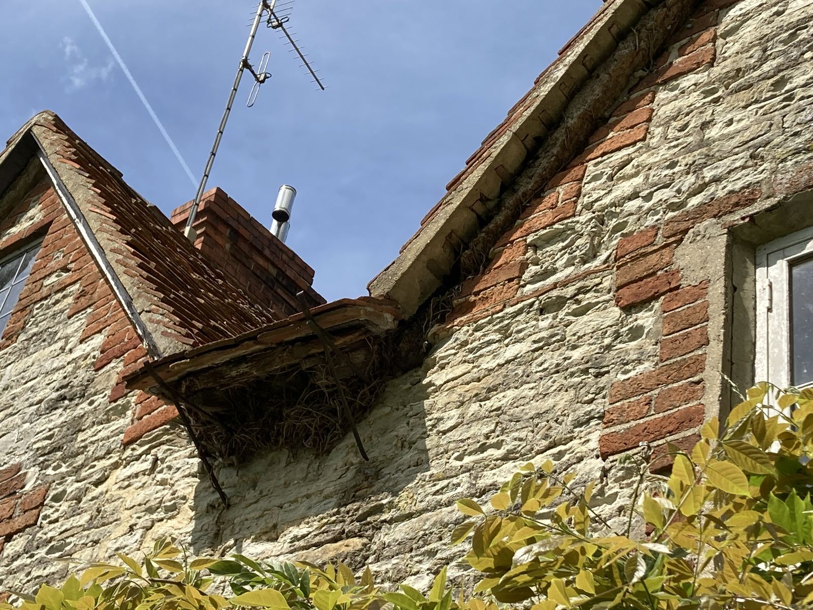 Sagging timber canopy and failing verge between stone and brick gables, photo 1 of 4