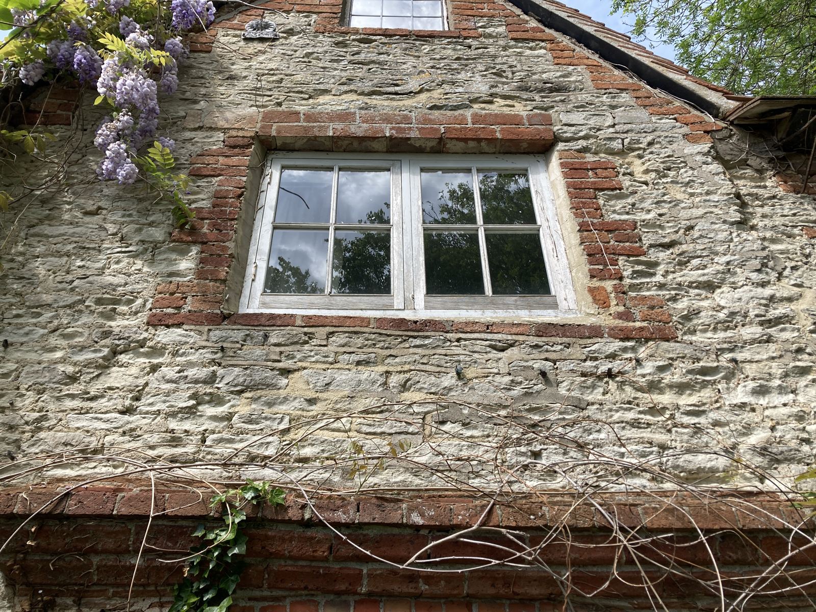 Stone gable with brick dressings, open joints and cement patching below the window, photo 4 of 4