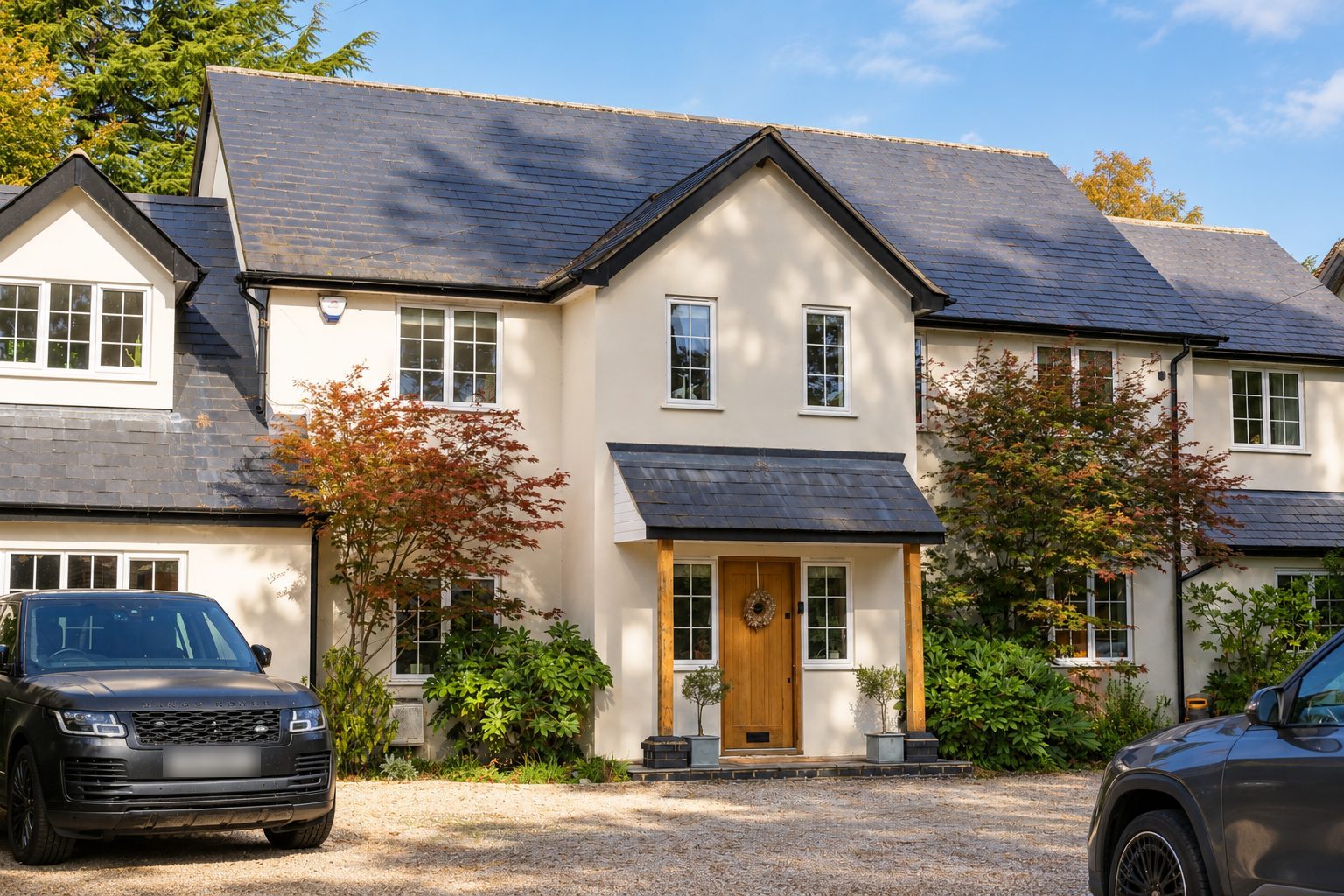 Rendered family home with slate roofs, oak porch and gravel drive