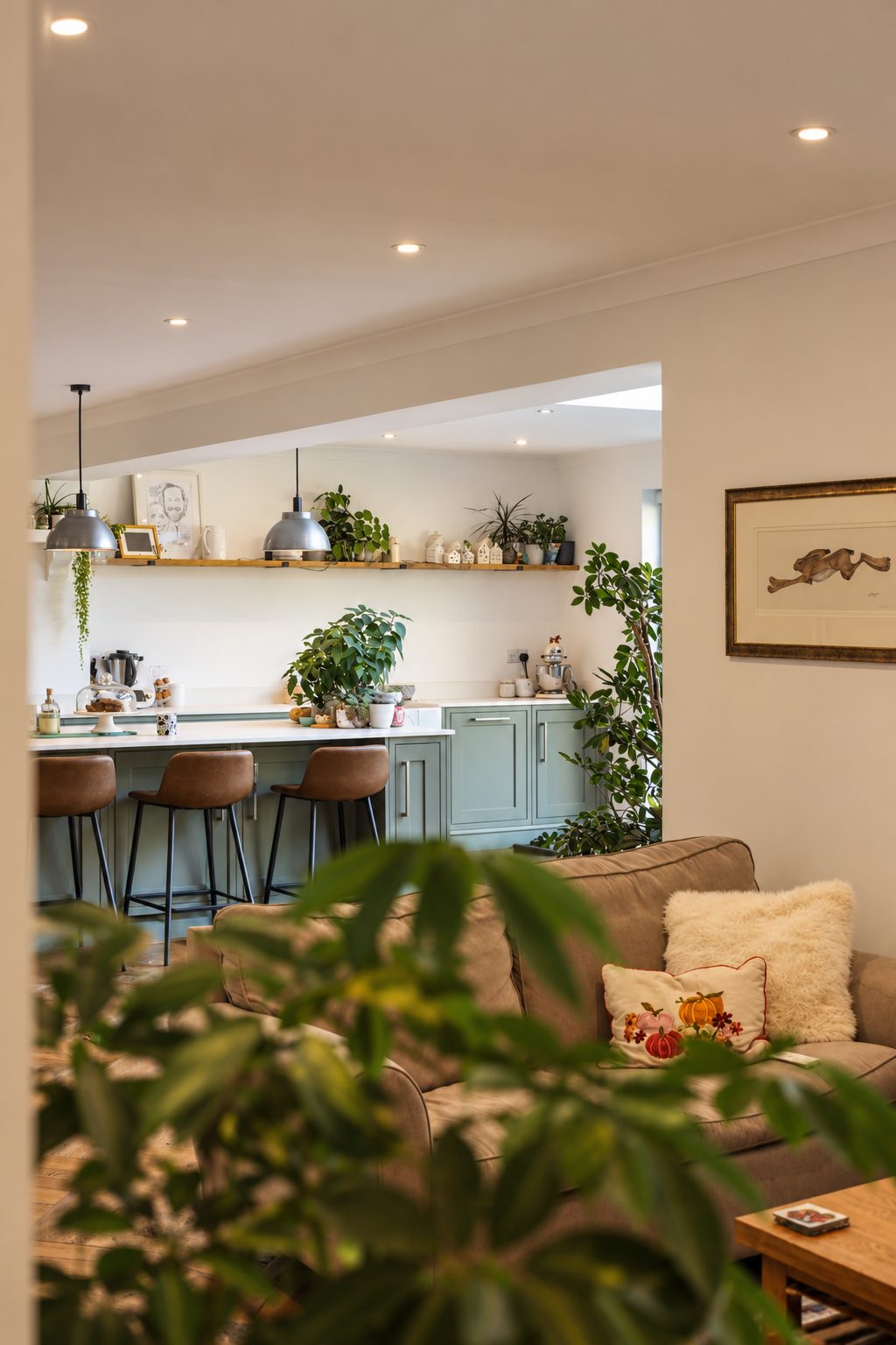 Open-plan living space with sofas and a kitchen breakfast bar
