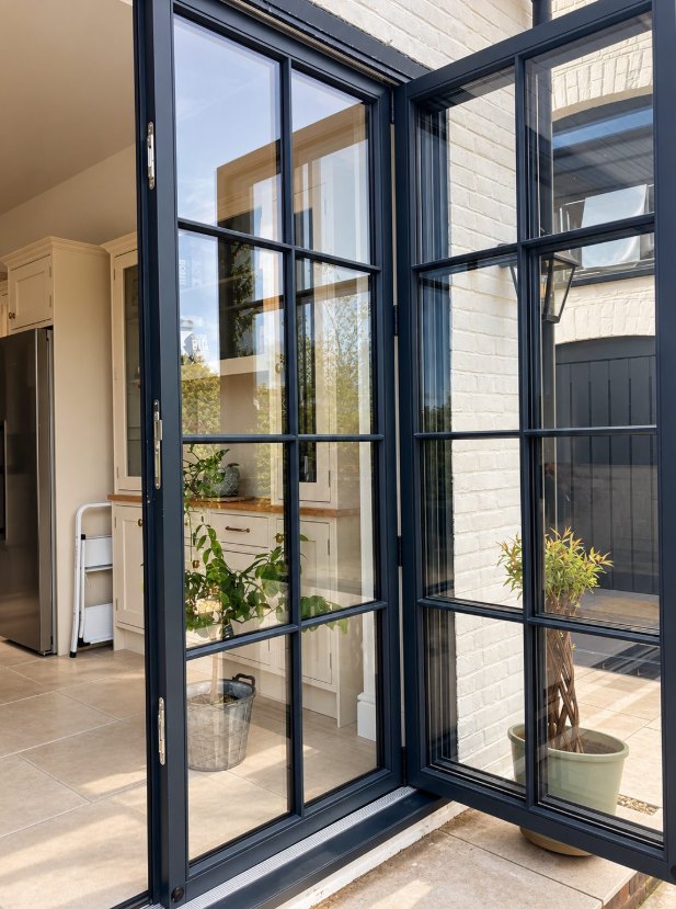 Slim black steel-look doors opening from a kitchen onto a terrace